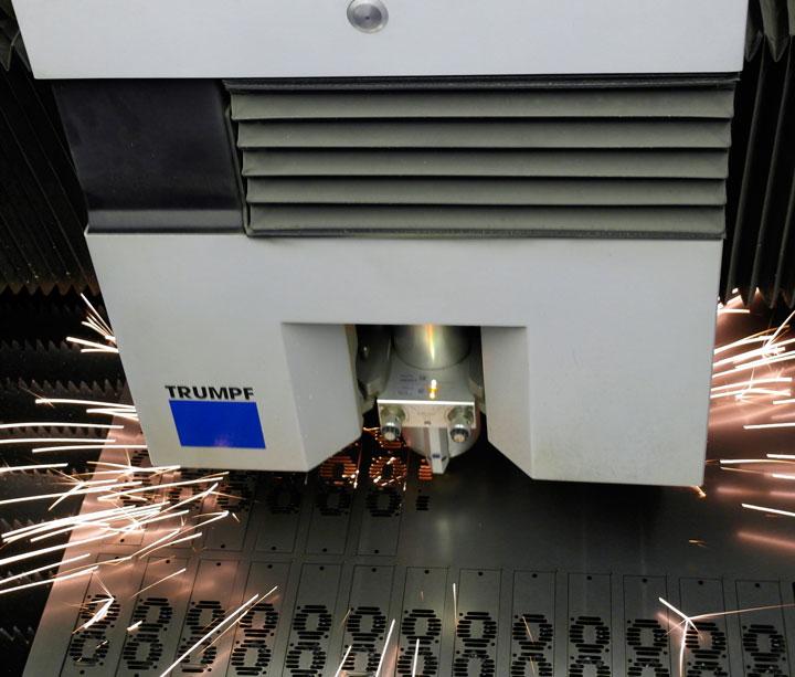 TRUMPF laser cutting head throwing sparks while cutting a steel sheet