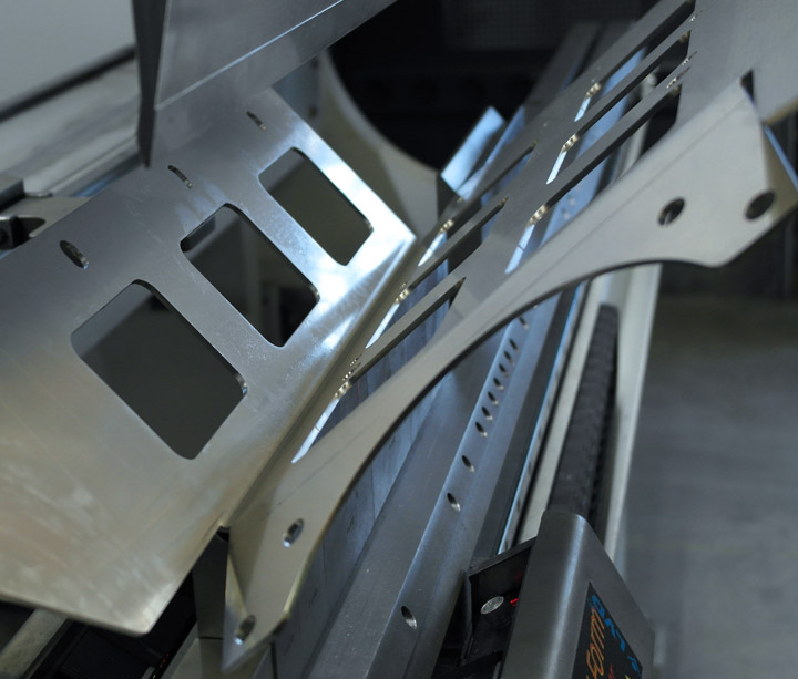 Laser-cut sheet-metal part with cut-outs held in a press brake